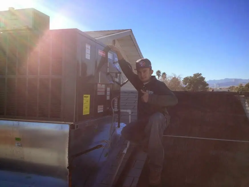 HVAC technician performing AC Tune-Up on a rooftop unit in Southbury